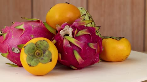 frutas de dragón y persimones artísticamente dispuestos juntos