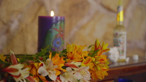 Schwenkaufnahme-Einer-Heilpflanze-In-Einer-Beruhigenden-Kerzenlichtumgebung-Mit-Blumen,-Rustikaler-Steinmauer-Und-Natürlichen-Heilmitteln