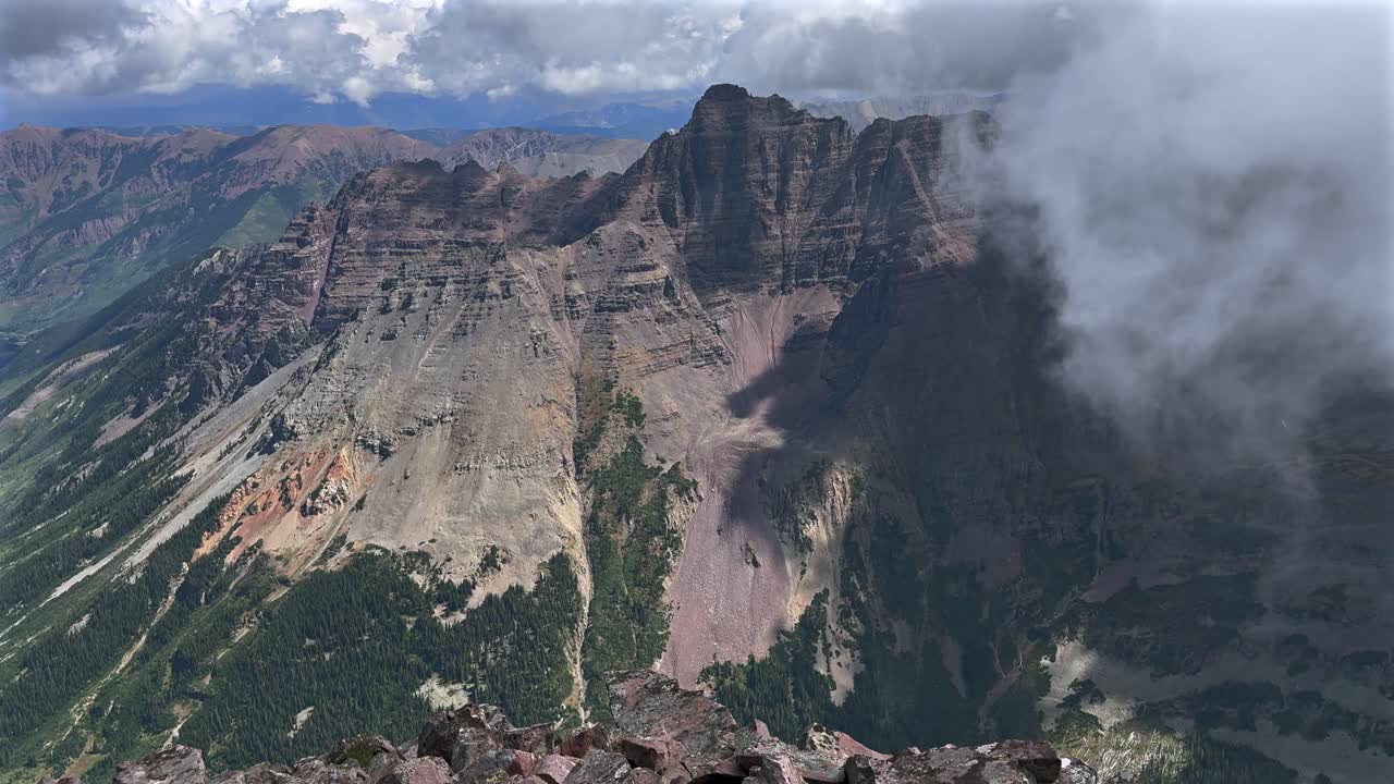Pyramid Peak Aspen Snowmmass Maroon Peak Maroon Bells Wilderness hiking fourteener Colorado summer aerial drone fog stormy weather clouds Elk Range Rocky Mountains rugged terrain static shot