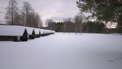 Eine-Lange-Reihe-Kleiner-Campinghütten-In-Verschneiter-Landschaft