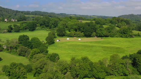 Amplia-Panorámica-Aérea-De-Grandes-Robles-Glamping-Día-Soleado-Reino-Unido-4k