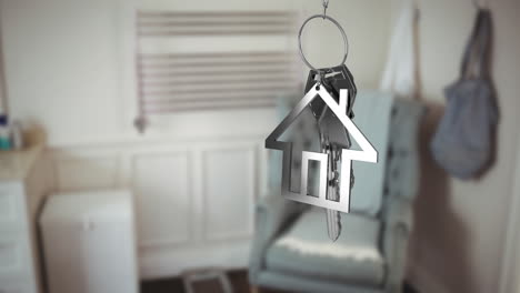 animation of silver key and house key ring over blurred house interior