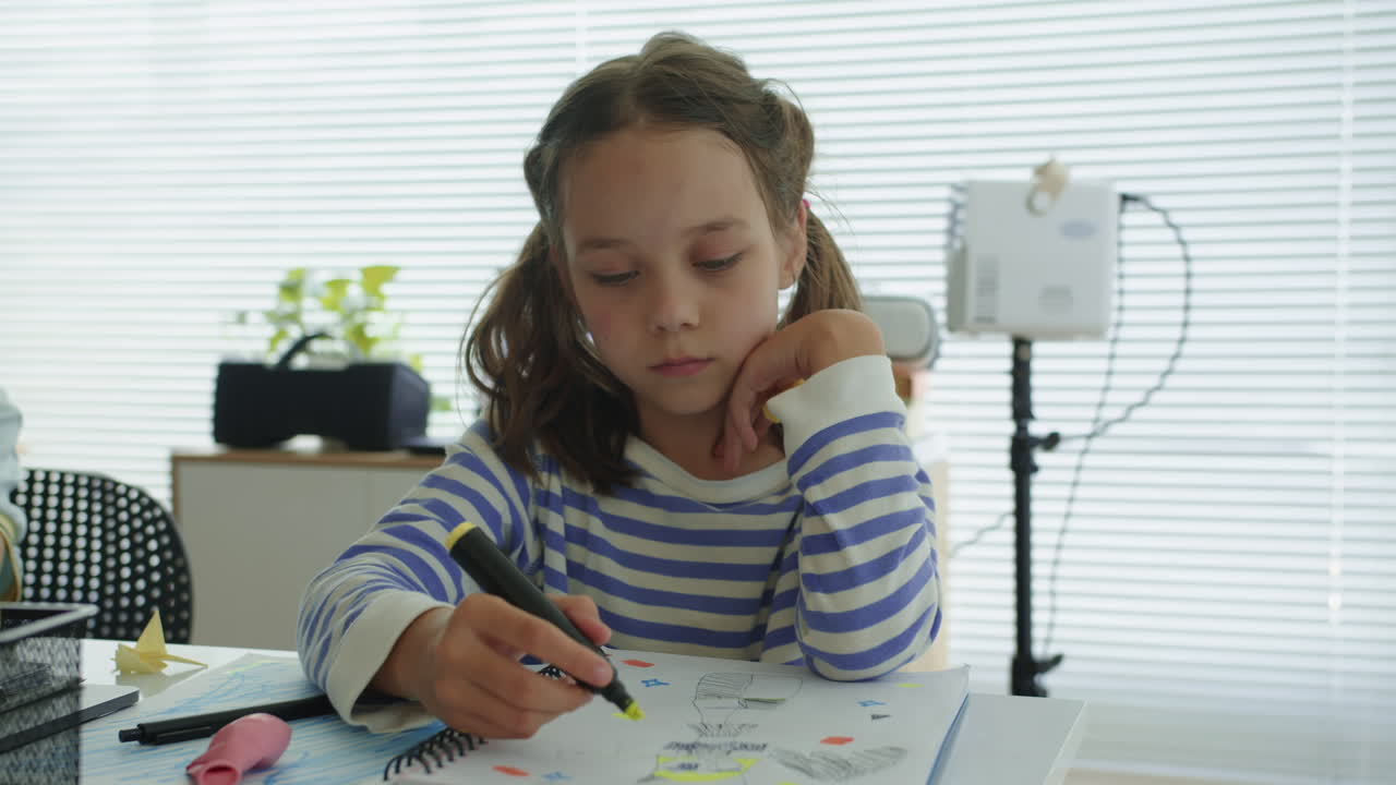 Portrait of Small Caucasian Girl Drawing at Notebook at School Desk