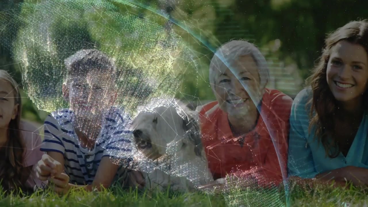 Multi-gen family lying on grass, globe overlay sweeping right revealing faces, supporting marketing