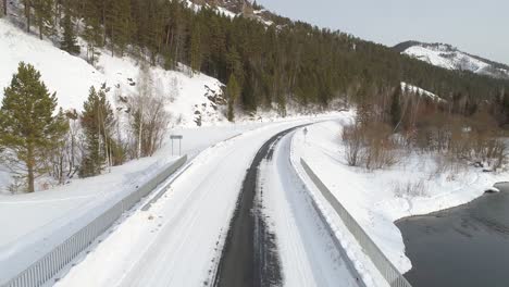 truck carrying logs on a snowy road in a forest