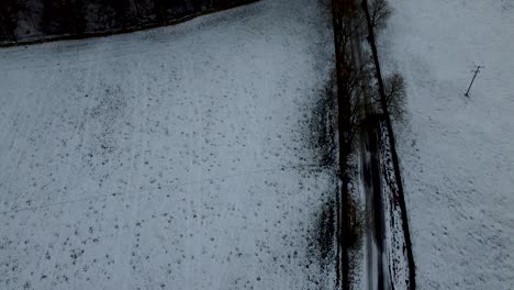 Aerial-topview-of-snowy-roads-and-meadows,-crossroad-and-some-trees