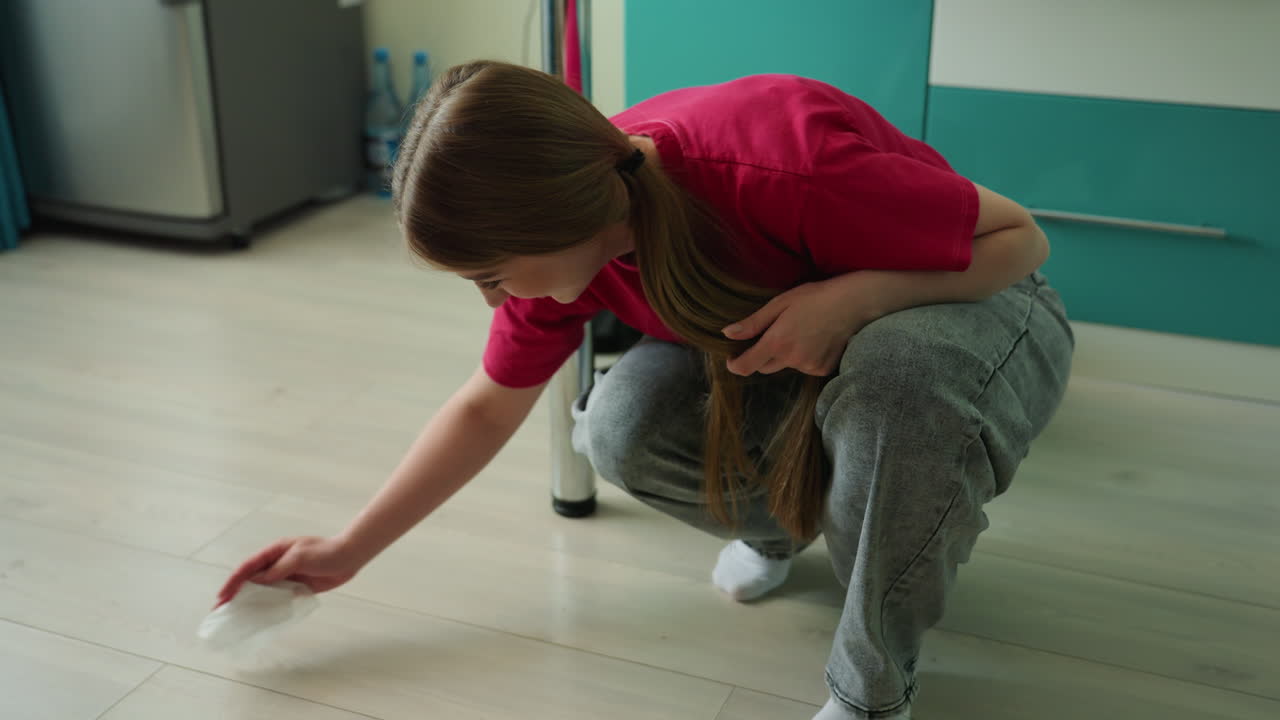 conserje ordenando, cuidador diligente recogiendo pañuelos con cuidado del suelo, cuidador dedicado limpiando meticulosamente pañuelos de la superficie laminada después de las actividades de cuidado del paciente