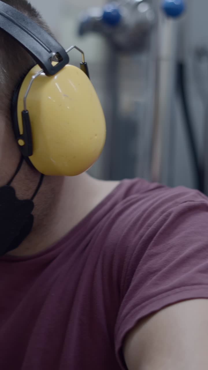 Young man wearing ear defenders and a face mask