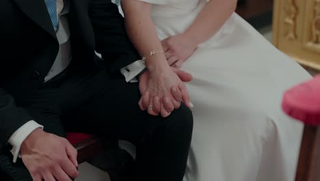 Close up of a bride and groom holding hands during their wedding ceremony, symbolizing love and commitment