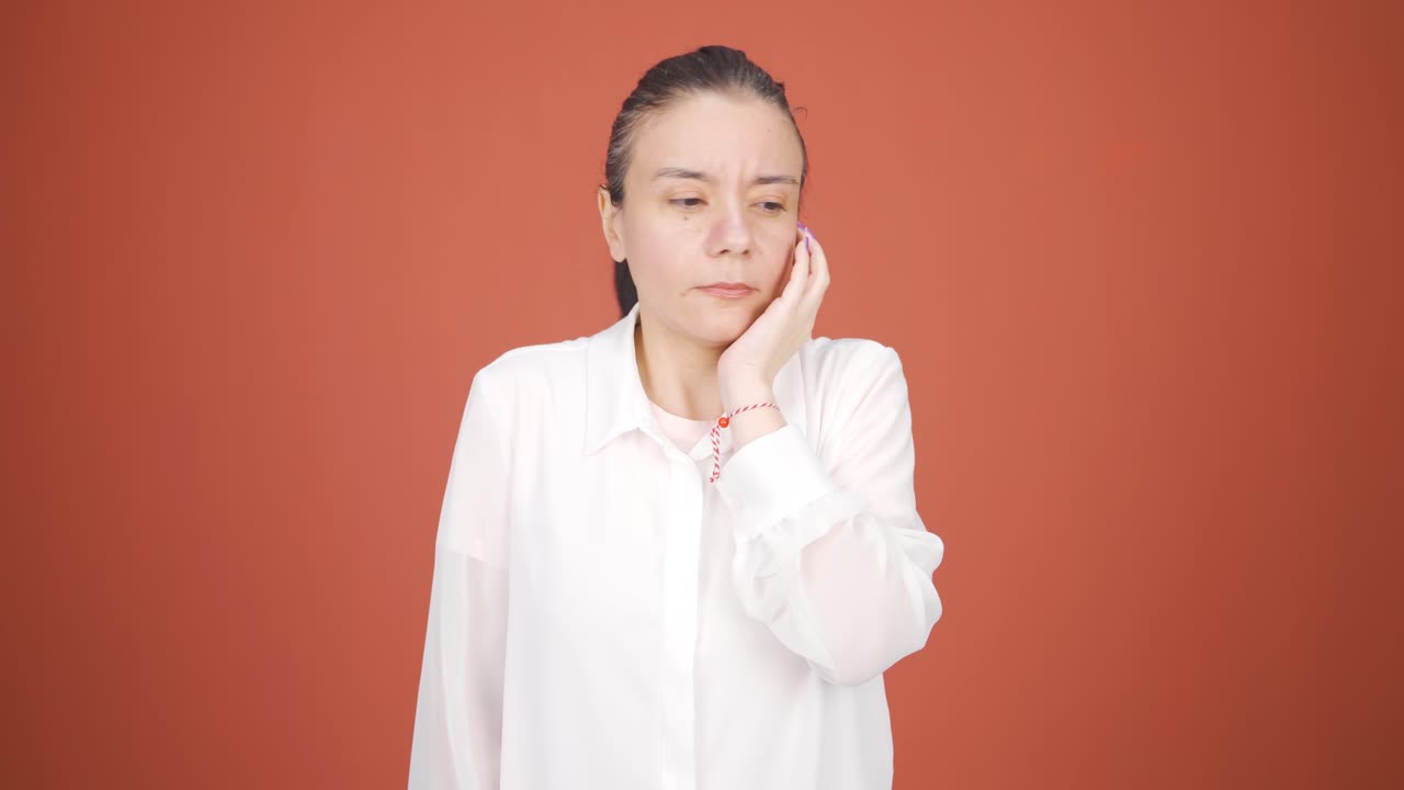 우울한 여성이 카메라를 바라보고 있습니다.