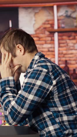 vertical video programmer in home office having deadline, stressed to finish debugging software