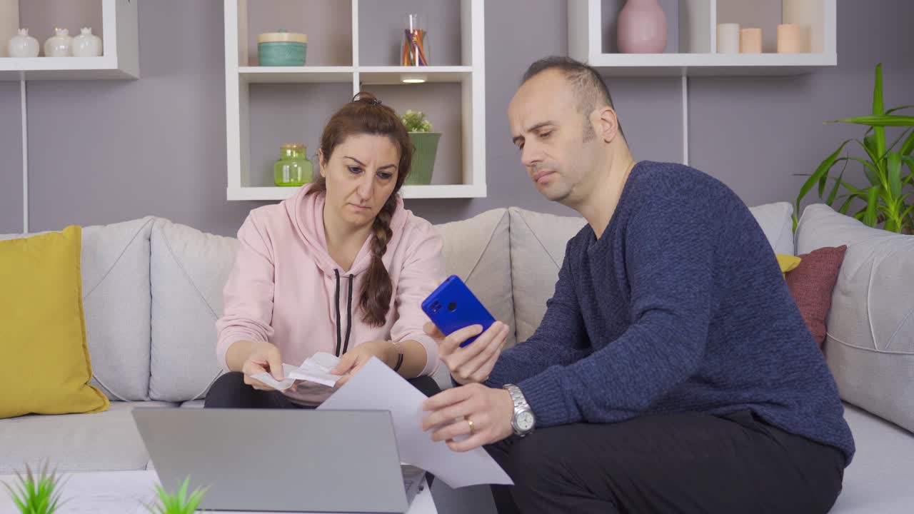 la pareja que calcula sus billetes de papel en casa está en una situación difícil. crisis económica.