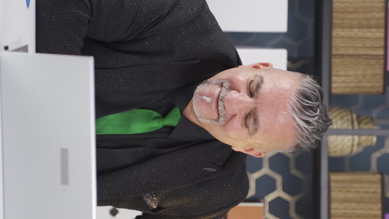 노트북에서 좋은 결과를 보는 사업가의 수직 비디오.