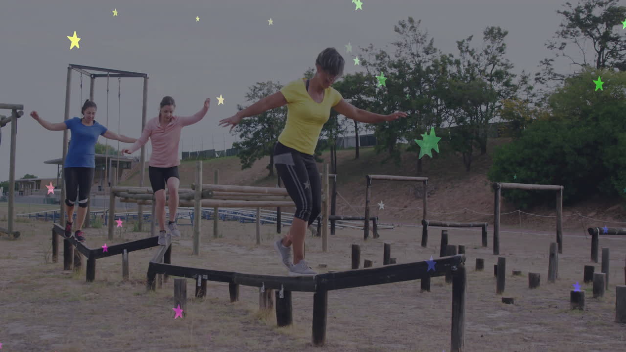 Women balancing on outdoor obstacle course with colorful star animation overlay