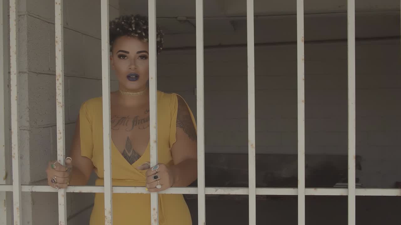 Portrait of Mixed Race Woman as Hostage Behind Bars in Prison Cell