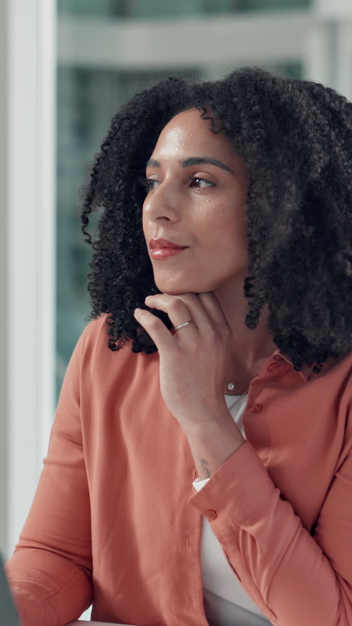Thoughtful Woman Working on Laptop in a Modern Office