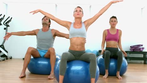 fitness class doing yoga on exercise balls