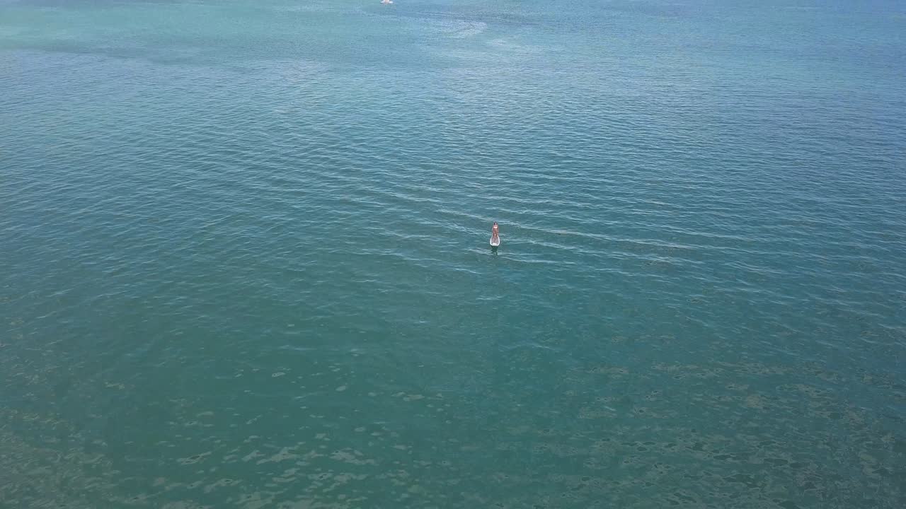 해안에서 멀리 떨어진 곳에서 저녁 식사를 즐기는 여성의 틸팅 드론 샷