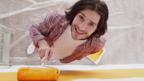 hombre pintando una pared de amarillo