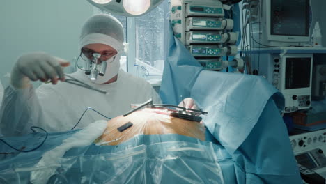 doctor does heart surgery with tools in clinic. cardio surgeon changes forceps to laser scalpel working in open patient chest in special medical center