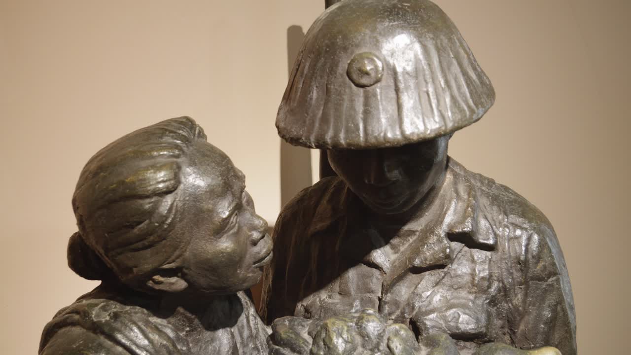 una escultura conmovedora que representa a una madre que ofrece un tazón de arroz a su hijo, un soldado, ubicada en el museo de historia militar de vietnam en hanoi, vietnam