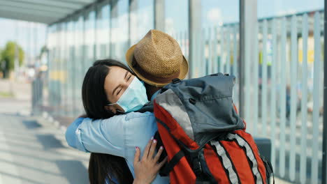 close-up view of happy caucasian young couple meeting at train station and hugging on nice summer day