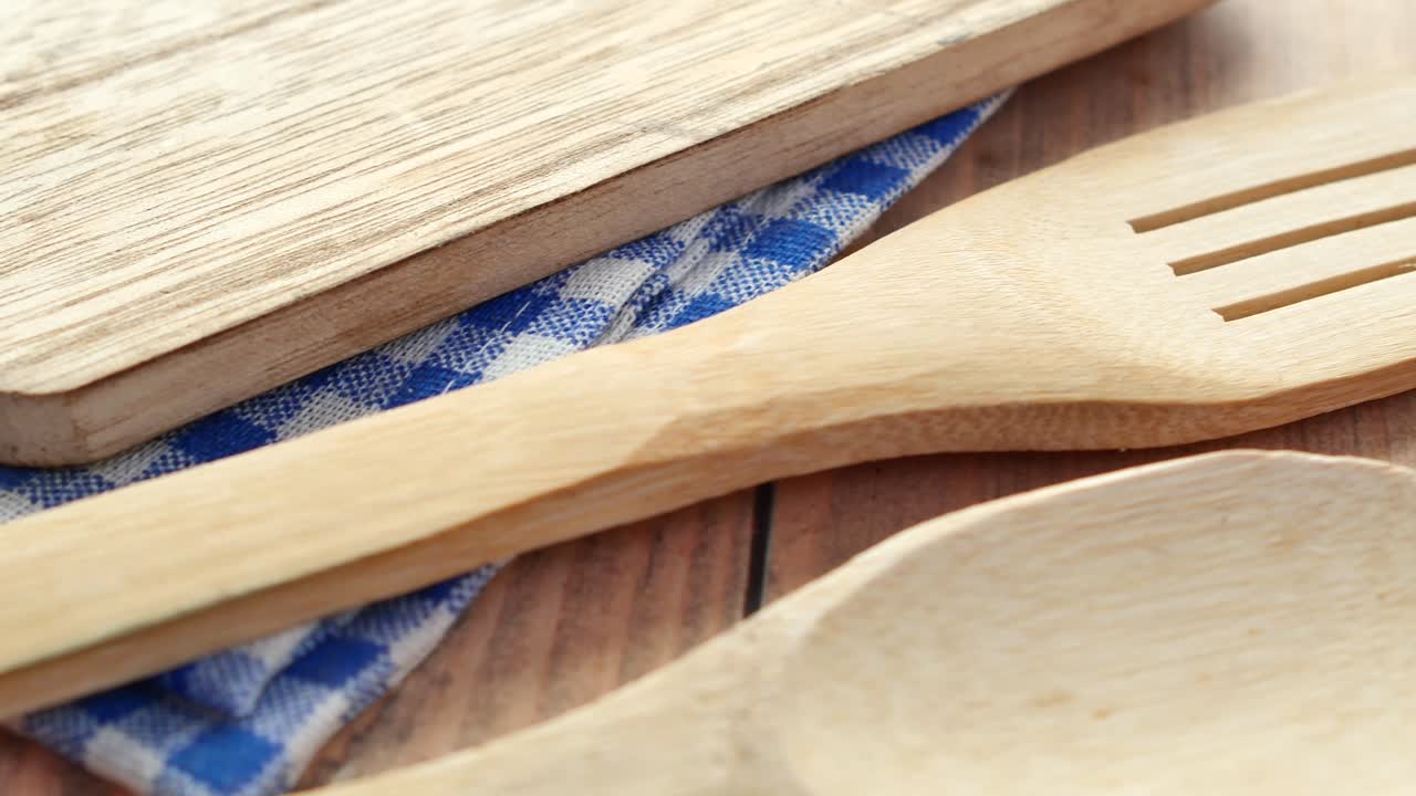 Wooden cutlery fork and spoon on a chopping board on table ,