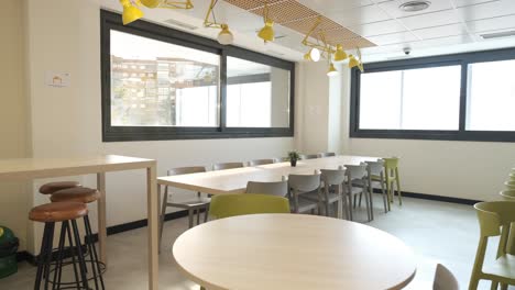 interior of office cafeteria with tables and chairs with glass windows