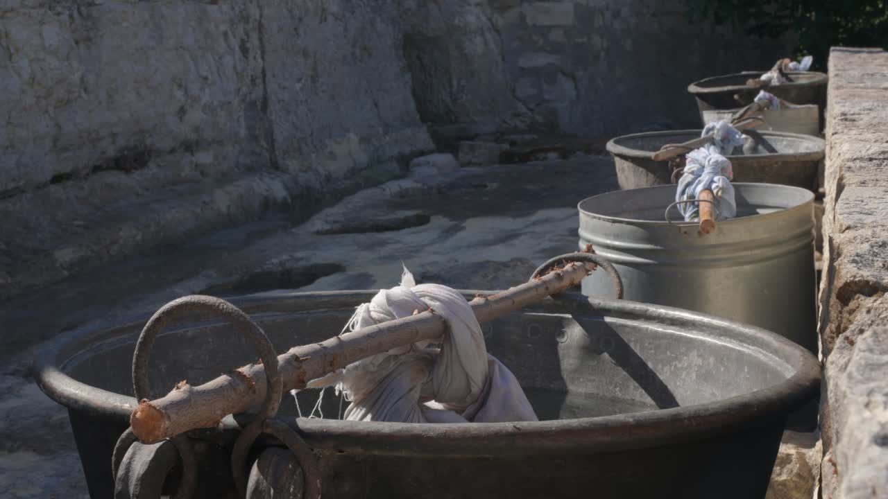 Caldaie tradizionali in rame con acqua fumante attendono che la donna del posto venga a fare il bucato, come si faceva nel 1900