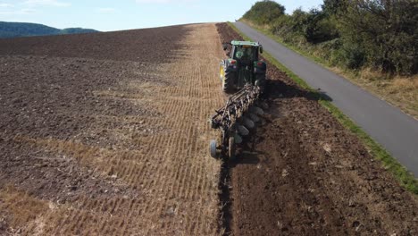 a tractor plows a field on a bright sunny day