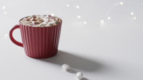 Video-of-red-mug-of-christmas-chocolate-with-marshmallows-and-copy-space-on-white-background