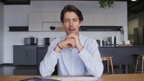 Caucasian-businessman-having-video-chat-looking-to-camera-in-workplce-kitchen