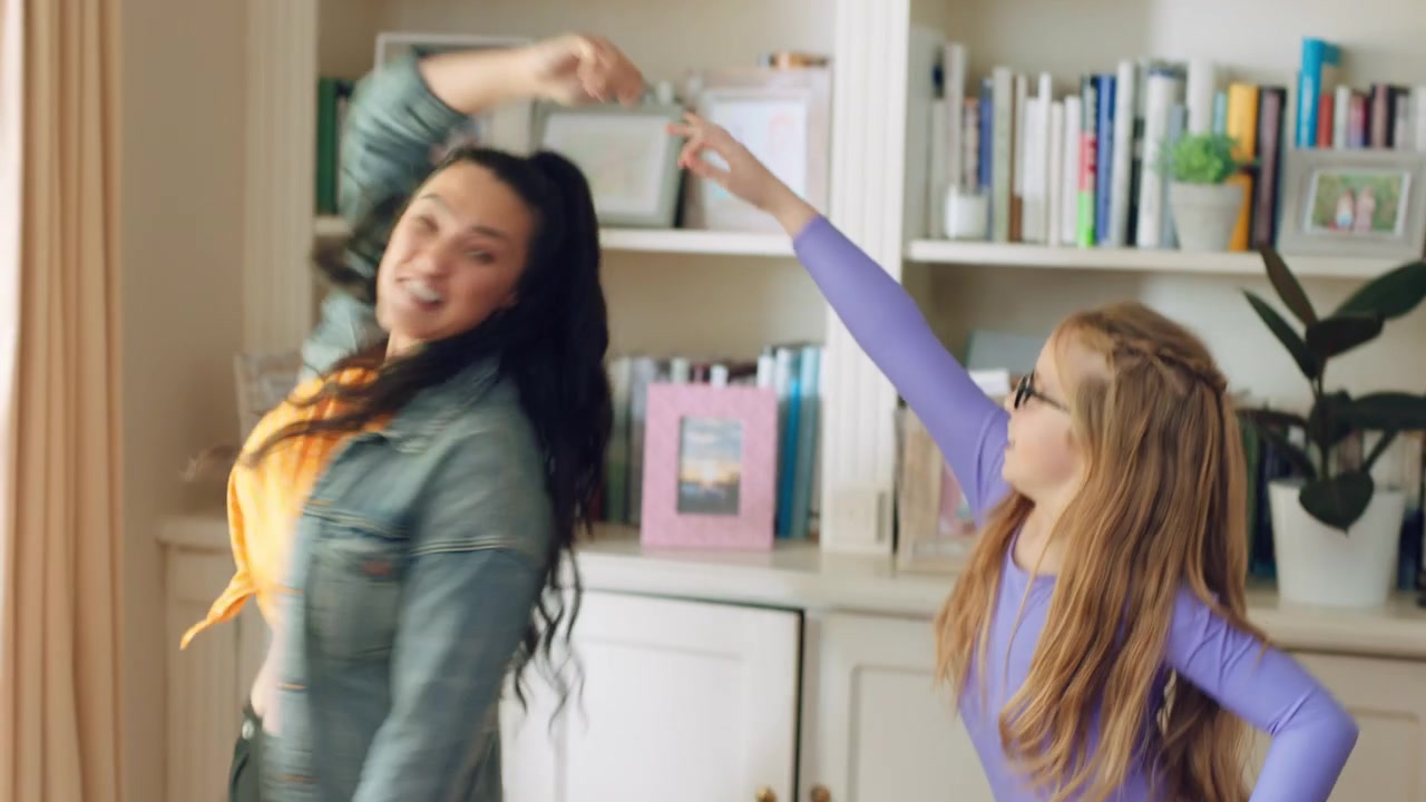 Young Woman and Little Girl Dancing Together at Home