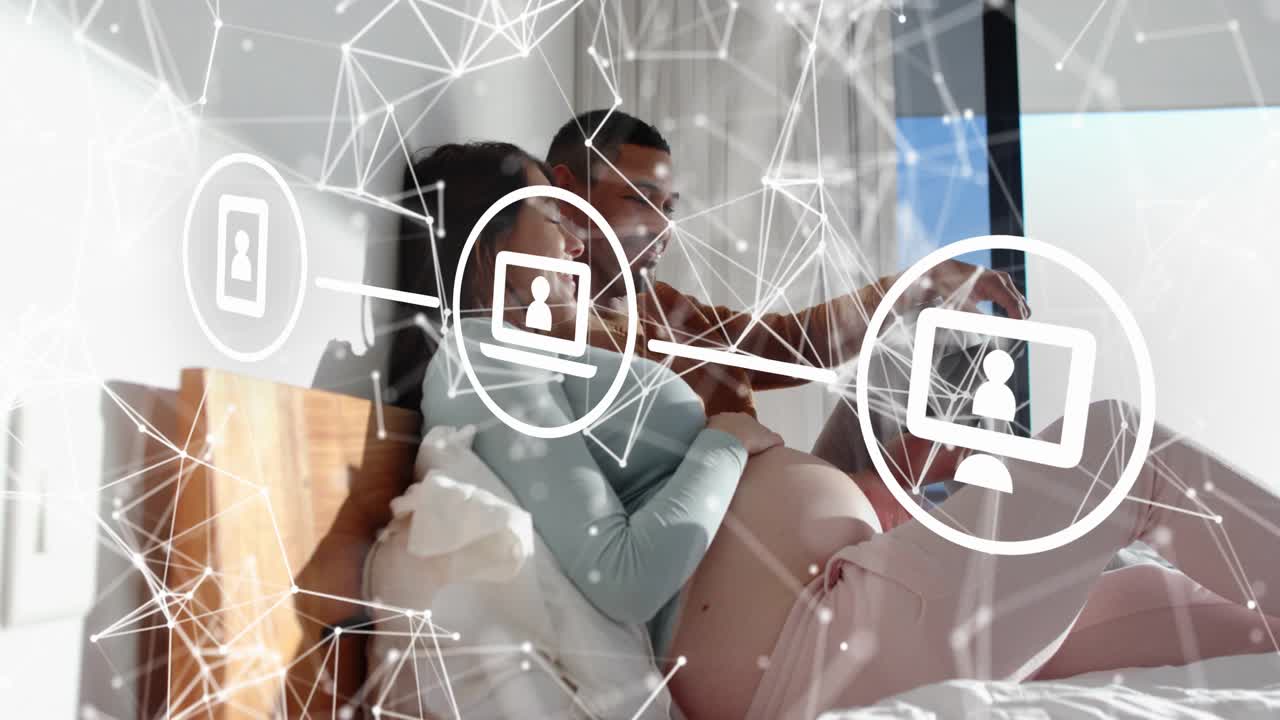 Pregnant woman and partner reclining bed, partner moving tablet, viewing prenatal charts with mesh