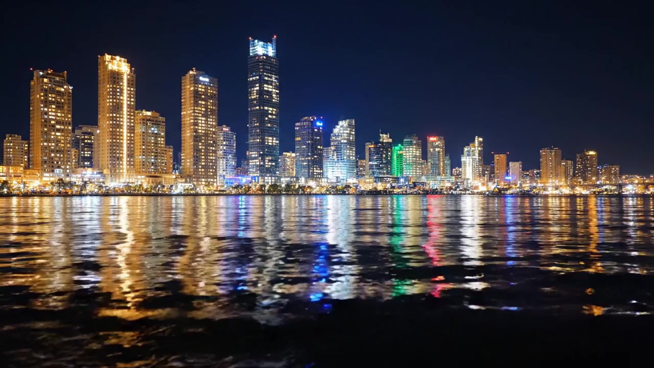 A Stunning Nighttime View of a City Skyline Reflected in Water, Highlighting Illuminated Buildings and Vibrant Lights in a Beautiful Urban Landscape
