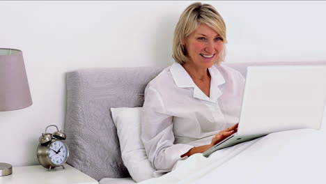 Mature-woman-using-laptop-in-her-bedroom