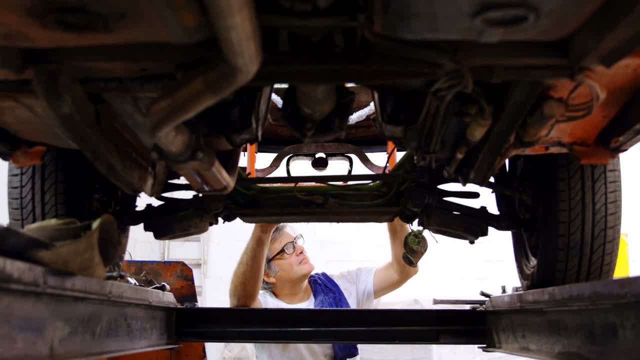 mecánico masculino haciendo servicio a un coche 4k