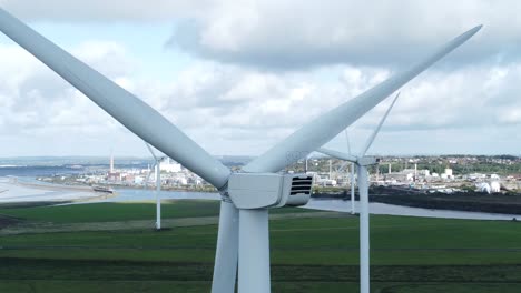 Alternative-green-energy-wind-farm-turbines-spinning-in-Frodsham-Cheshire-fields-aerial-view-closeup-dolly-right