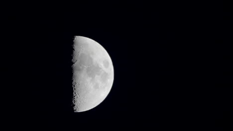 A-shot-of-a-first-quarter-moon-slowly-rising-from-up-in-the-sky-in-Tokyo,-Japan