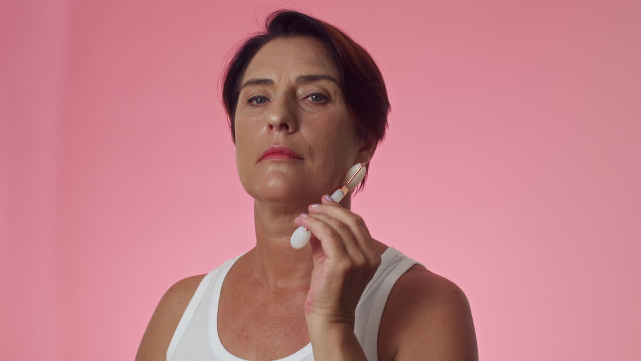 Gen X Woman Massaging Face with Jade Roller
