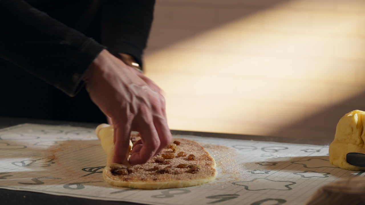 Baker's Hands Rolling Up Cinnamon Dough With Fillings. Cinnamon Roll Making. closeup shot