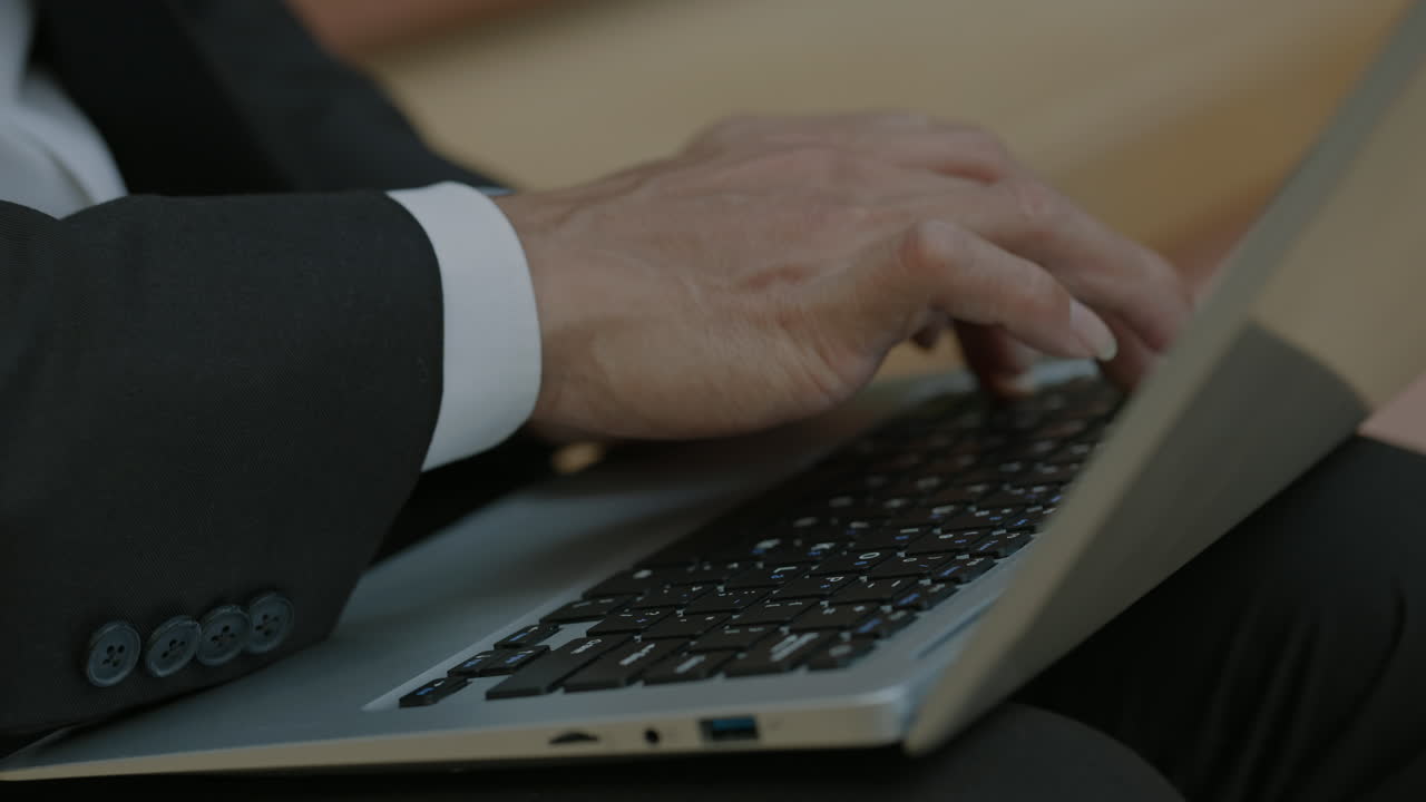 ノートPCのキーボードを打つプロの手元クローズアップ