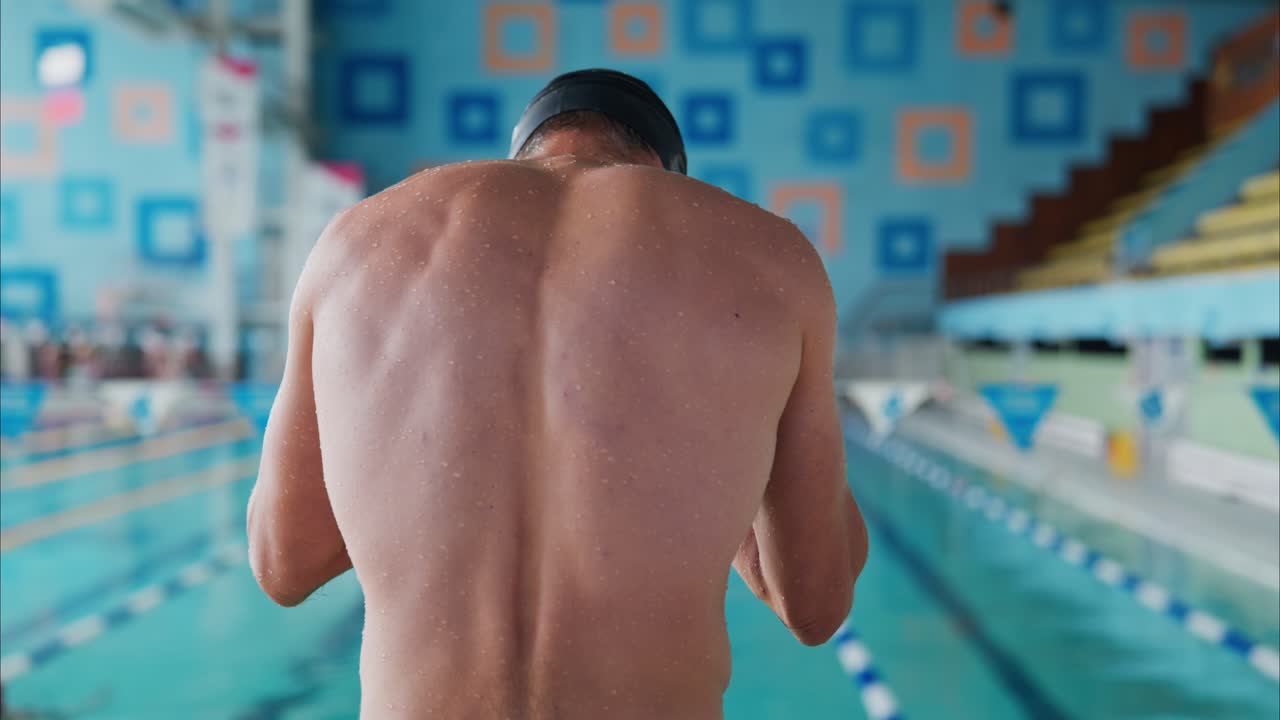 A swimmer poised at the edge of a pool, preparing for competition with determination and focus, showcasing athleticism in a vibrant training environment