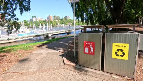 sequence of recycling bins by a pathway in a sunny park