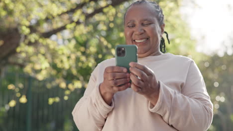 Senior-woman,-smartphone-and-texting-in-park