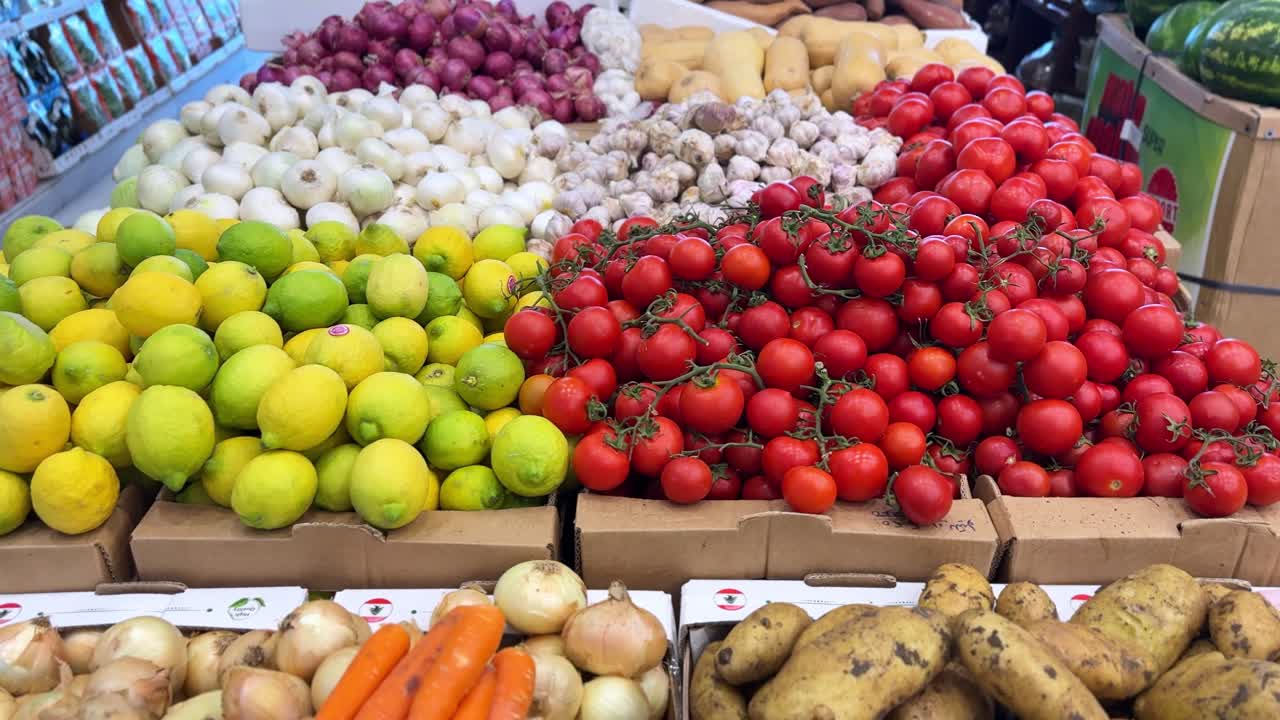 Vibrant 4K shot of fresh tomatoes, lemons, garlic, onions, and squash at a produce market. Perfect for food, nutrition, retail, or healthy living content.