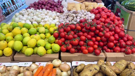 vibrant 4k shot of fresh tomatoes, lemons, garlic, onions, and squash at a produce market. perfect for food, nutrition, retail, or healthy living content.