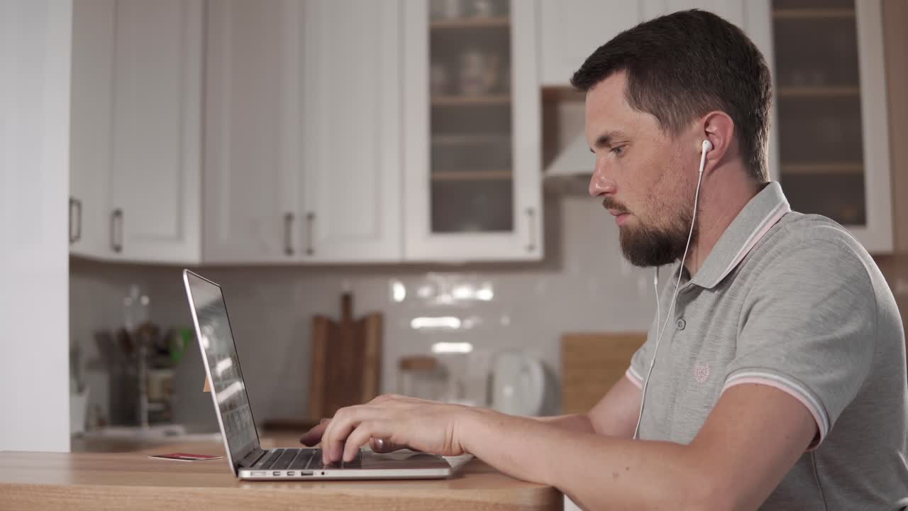 hombre trabajando en una computadora portátil en la cocina