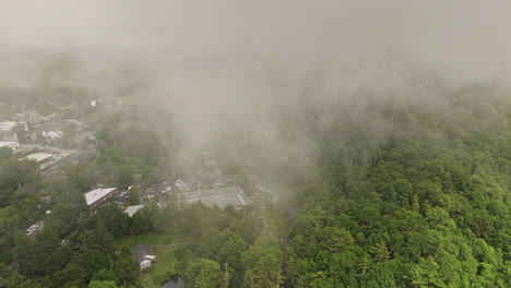 Highlands-North-Carolina-Aerial-v1-cinematic-drone-fly-through-thick-misty-clouds,-reveals-small-mountain-town-surrounded-by-lush-green-mountainous-landscape---Shot-with-Mavic-3-Cine---July-2022