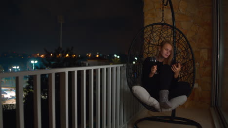 Woman-reading-phone-with-wine